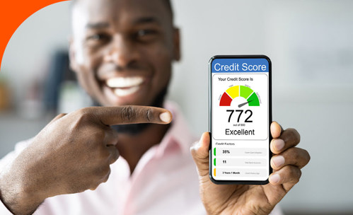 Man smiling and pointing to his smartphone that’s open on a credit score app.