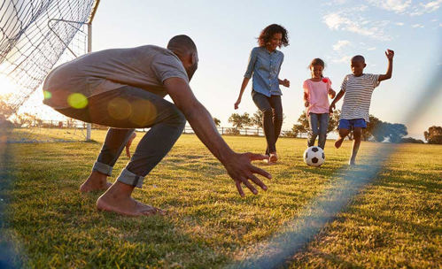 Family of four playing soccer