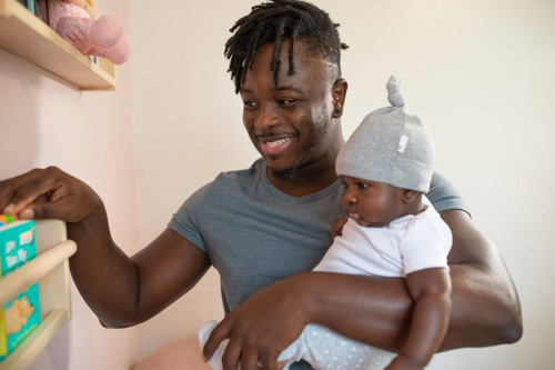 A man joyfully holds a baby in his arms