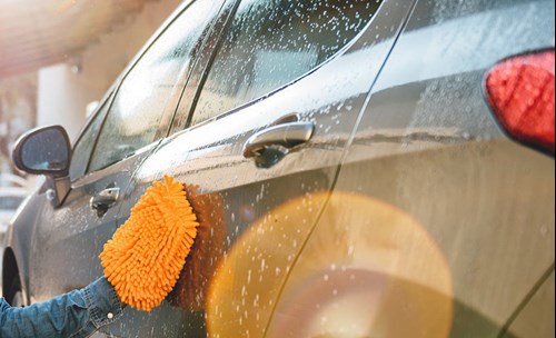 Person washing car exterior