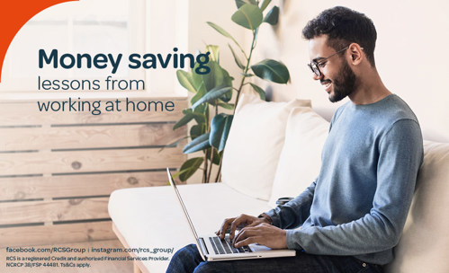 Man sitting on couch, working on laptop, smiling