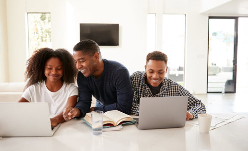 Family working on laptops together and smiling