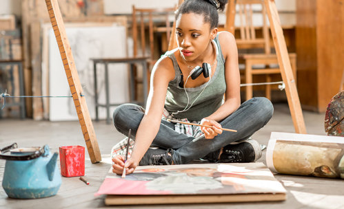 Woman sitting on the floor, painting