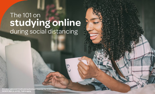 Smiling woman working on laptop with mug in her hand