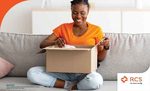 Woman sitting on couch unpacking a box